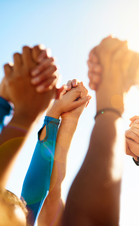 hands joining together in unity against a bright sky symbolizing strength and teamwork in overcoming challenges and celebrating victories together as a group of seven